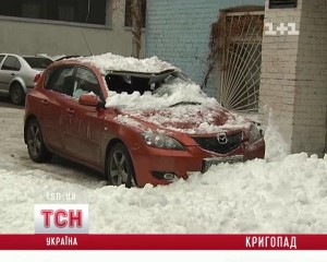 В центре Киева громадная куча снега раздавила красную Мазду